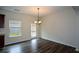 Bright dining area with hardwood floors, chandelier, and a view of the backyard through a window at 2671 Calvary Dr, Hampton, GA 30228