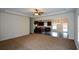 Open-concept living room that flows into the kitchen, featuring neutral carpet and plenty of natural light at 2671 Calvary Dr, Hampton, GA 30228