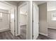 Hallway with gray vinyl floors leads to updated bathroom with glass shower and adjacent bedroom at 2968 Cleburne Pkwy, Powder Springs, GA 30127