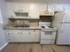 Kitchen with white cabinets, sink, and white electric range at 2968 Cleburne Pkwy, Powder Springs, GA 30127