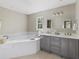 Bright main bathroom featuring double sinks, a soaking tub, and tiled floors at 4468 Windsor Oaks Dr, Marietta, GA 30066