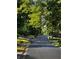 Street leading into the neighborhood with mature trees lining the road and landscaping at 4468 Windsor Oaks Dr, Marietta, GA 30066