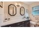 Well-lit bathroom featuring dual mirrors, a white countertop, and classic tiled walls at 5478 Janice Ln, Stone Mountain, GA 30087