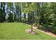 This backyard has mature trees, a split rail fence, and a lush green lawn perfect for entertaining or enjoying the peace of nature at 1150 Sweet Mia Ln, Powder Springs, GA 30127