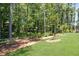 This backyard has mature trees, a split rail fence, and a lush green lawn perfect for entertaining or enjoying the peace of nature at 1150 Sweet Mia Ln, Powder Springs, GA 30127