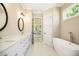 Luxurious bathroom with double vanity, soaking tub, and natural light enhancing its spa-like atmosphere at 1150 Sweet Mia Ln, Powder Springs, GA 30127