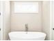 Close-up of a modern soaking tub with sleek fixtures and a window providing natural light at 1150 Sweet Mia Ln, Powder Springs, GA 30127