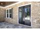 Charming home exterior showcasing a stylish brick facade, double entry doors, and a large window at 1150 Sweet Mia Ln, Powder Springs, GA 30127