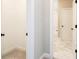 Hallway view to a bathroom featuring marble floors and a tub shower at 1150 Sweet Mia Ln, Powder Springs, GA 30127