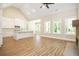 Spacious living room featuring a kitchen, fireplace, wood floors, and large windows at 1150 Sweet Mia Ln, Powder Springs, GA 30127