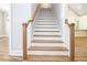 Elegant staircase with wooden treads, white risers, and a matching wooden handrail, leading to the upper level at 1150 Sweet Mia Ln, Powder Springs, GA 30127
