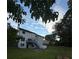 Backyard view with a two-story home and deck, surrounded by lush greenery and blue skies at 1951 Bergerac Sw Ct, Marietta, GA 30008