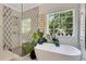 Stylish bathroom with a glass-enclosed shower, a modern soaking tub, and a large window for natural light at 47 Roseclair Se Dr, Atlanta, GA 30317
