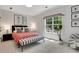 Cozy bedroom featuring a comfortable bed, accent wall art, and a window with a view of the outdoors at 47 Roseclair Se Dr, Atlanta, GA 30317