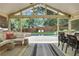 Inviting sunroom with comfortable seating, outdoor dining, and a view of the pool and lush backyard at 47 Roseclair Se Dr, Atlanta, GA 30317