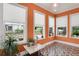 Bright sunroom featuring orange walls, geometric tile flooring, and natural light from many windows at 47 Roseclair Se Dr, Atlanta, GA 30317
