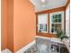 Bright sunroom featuring orange walls, geometric tile flooring, and natural light from two windows at 47 Roseclair Se Dr, Atlanta, GA 30317