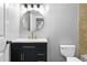 Updated bathroom features a sleek black vanity with gold fixtures, a round mirror and modern lighting at 5925 Water Mark Dr, Cumming, GA 30040