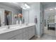 Bright bathroom with dual sinks, white cabinets, framed mirror, and an adjoining bedroom at 5925 Water Mark Dr, Cumming, GA 30040