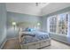 A bedroom with blue walls, beige carpet, window, and bed with under-the-bed storage drawers at 5925 Water Mark Dr, Cumming, GA 30040