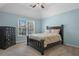 A bedroom with blue walls, carpet, window with blinds, bed, and dresser at 5925 Water Mark Dr, Cumming, GA 30040