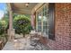 Cozy covered porch with stone flooring, brick columns, and a quaint seating area at 5925 Water Mark Dr, Cumming, GA 30040