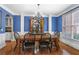 Formal dining room with blue walls, hardwood floors, and elegant chandelier at 5925 Water Mark Dr, Cumming, GA 30040