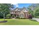 Charming two-story brick home with stone accents, well-manicured lawn, and mature trees at 5925 Water Mark Dr, Cumming, GA 30040