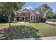 Beautifully landscaped front yard with mature trees and lush green lawn on a sunny day at 5925 Water Mark Dr, Cumming, GA 30040