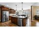 Bright kitchen featuring dark wood cabinets, hardwood floors, a large island, and stainless steel appliances at 5925 Water Mark Dr, Cumming, GA 30040