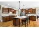 Modern kitchen with granite countertops, hardwood floors, dark wood cabinets, island and stainless appliances at 5925 Water Mark Dr, Cumming, GA 30040