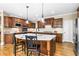 Modern kitchen with granite countertops, hardwood floors, dark wood cabinets, island, and stainless steel appliances at 5925 Water Mark Dr, Cumming, GA 30040
