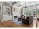Bright living room featuring hardwood floors, fireplace, built-in shelves, and abundant natural light from large windows at 5925 Water Mark Dr, Cumming, GA 30040
