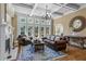 Bright living room featuring hardwood floors, fireplace, and large windows with backyard views at 5925 Water Mark Dr, Cumming, GA 30040