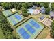 Aerial view of community tennis courts, basketball court and a playground surrounded by lush greenery at 5925 Water Mark Dr, Cumming, GA 30040