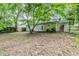 Backyard view with a shade tree, grass, and back door to the cream colored house at 6185 Marbut Farms, Lithonia, GA 30058