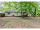 A view of the backyard with a covered lawn and a back view of the home with cream colored siding at 6185 Marbut Farms, Lithonia, GA 30058
