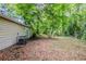 Backyard featuring a lush, wooded area with a mature tree at 6185 Marbut Farms, Lithonia, GA 30058