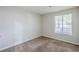A carpeted bedroom with neutral walls, window, and natural light at 6185 Marbut Farms, Lithonia, GA 30058