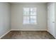 An empty bedroom with neutral walls, a window, and a closet door at 6185 Marbut Farms, Lithonia, GA 30058