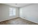 A carpeted bedroom with neutral walls, a window, and a closet door at 6185 Marbut Farms, Lithonia, GA 30058