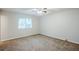 Bright bedroom with carpeted floors, neutral paint, and a large window for natural light at 6185 Marbut Farms, Lithonia, GA 30058