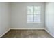 An empty bedroom with a window and neutral-colored carpet at 6185 Marbut Farms, Lithonia, GA 30058