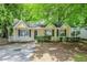 Charming yellow home featuring a well-kept lawn and mature shade trees creating curb appeal at 6185 Marbut Farms, Lithonia, GA 30058