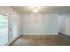 Neutral living room features carpeted floors, white walls, and french doors to outside at 6185 Marbut Farms, Lithonia, GA 30058