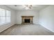Cozy living room with stone fireplace, ceiling fan, and large window bringing in natural light at 6185 Marbut Farms, Lithonia, GA 30058