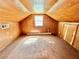 View of the attic with paneled walls, carpet and a window letting in natural light at 1292 Lorenzo Sw Dr, Atlanta, GA 30310
