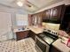 Galley kitchen with brown cabinets, stainless steel appliances, and vinyl flooring at 1292 Lorenzo Sw Dr, Atlanta, GA 30310