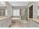 Well-lit bathroom featuring double vanities, a tub, and a glass-enclosed shower at 1547 Cambridge Pl, Marietta, GA 30062