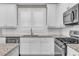 Detailed view of a modern kitchen featuring white cabinets, granite countertops, and stainless steel appliances at 1547 Cambridge Pl, Marietta, GA 30062